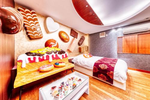 Spavaća soba sa jastucima u obliku krofni i slikama u obliku slatkiša u Sweets Hotel Machida Tokyo