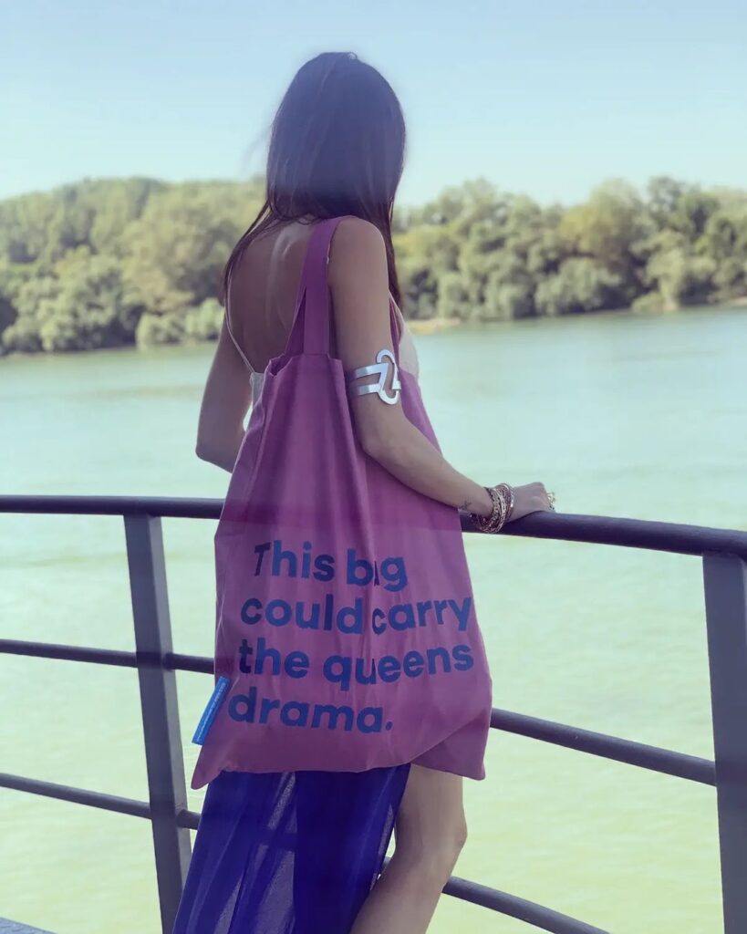 „This bag could carry the queens drama" sa plavim slovima i rozom podlogom