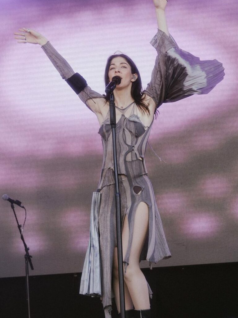 Caroline Polachek u krem-ljubičastoj haljini na koncertu